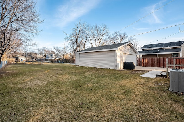 view of yard with a trampoline, a garage, an outdoor structure, and central AC