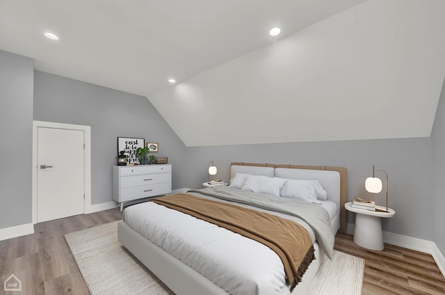 bedroom with hardwood / wood-style flooring and lofted ceiling