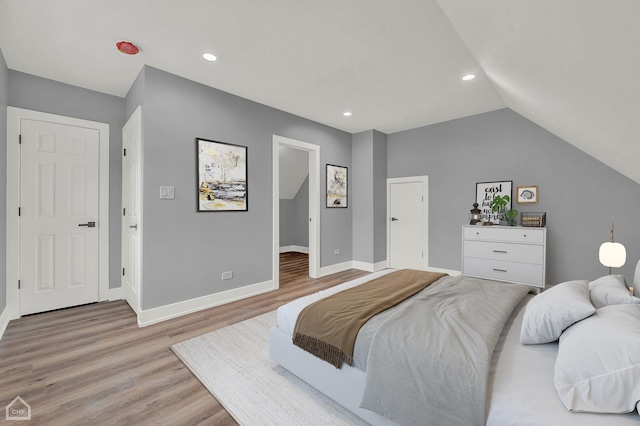 bedroom featuring vaulted ceiling and light wood-type flooring