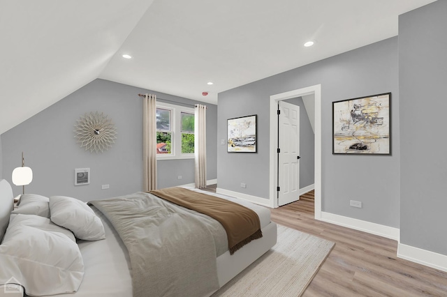 bedroom featuring vaulted ceiling and light wood-type flooring