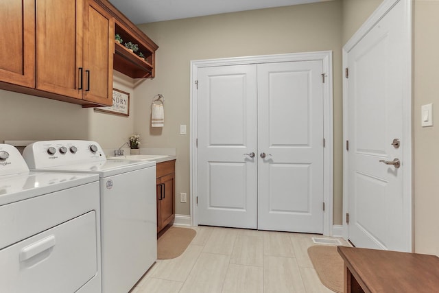 washroom featuring washer and clothes dryer, cabinet space, and baseboards