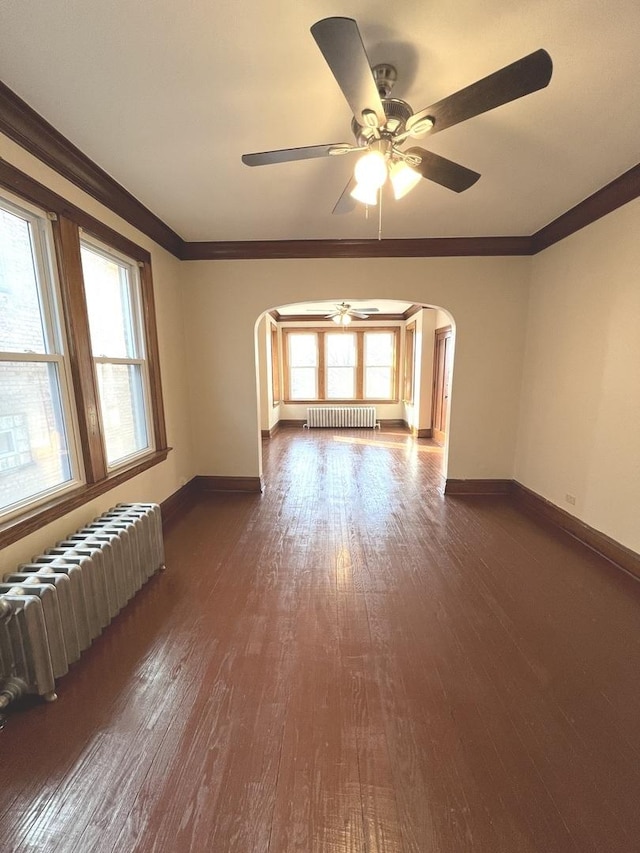 spare room with radiator, crown molding, and dark wood-type flooring