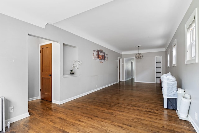 empty room with dark wood-type flooring and baseboards