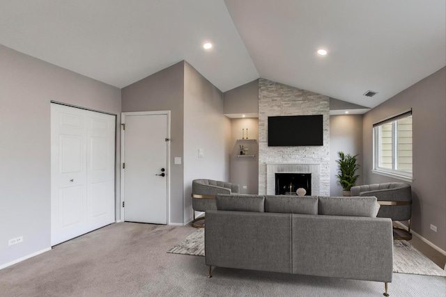 living room with a large fireplace, lofted ceiling, and light carpet