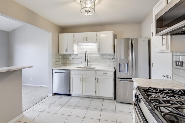 kitchen with white cabinetry, light colored carpet, appliances with stainless steel finishes, and sink