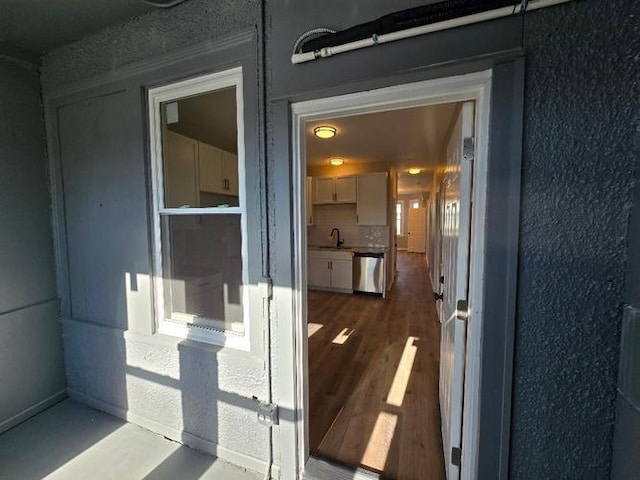 doorway to property featuring a sink and stucco siding