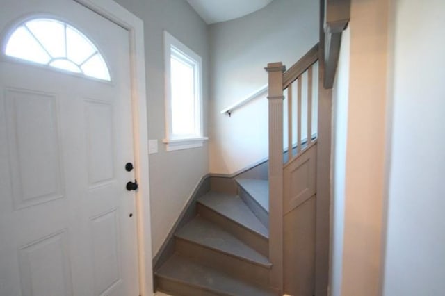 entryway featuring stairs and baseboards