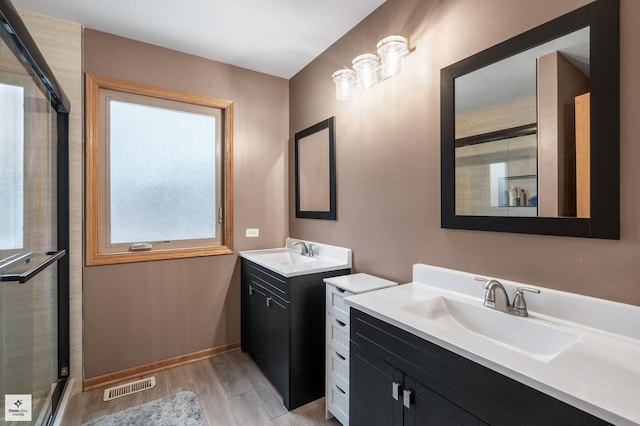 bathroom with vanity, an enclosed shower, and hardwood / wood-style flooring