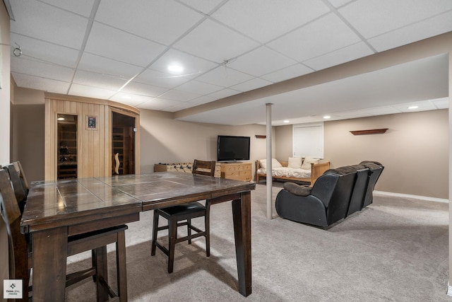 dining space with carpet flooring and a drop ceiling