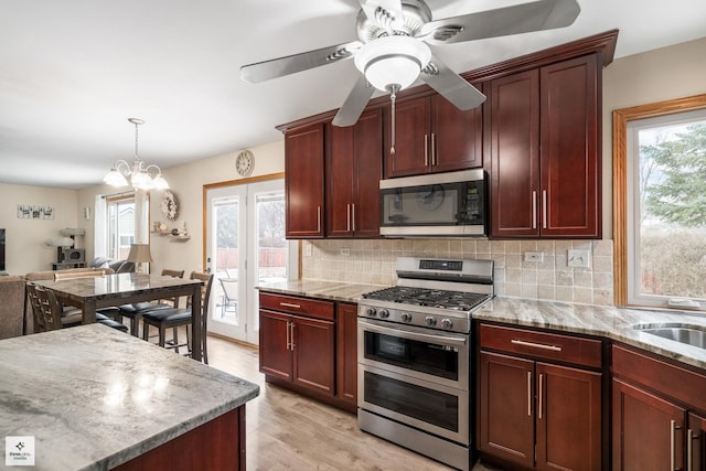 kitchen featuring plenty of natural light, stainless steel appliances, light hardwood / wood-style floors, and backsplash