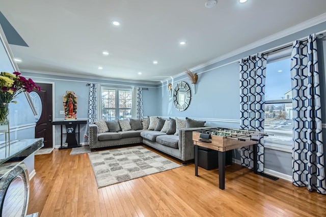 living room featuring ornamental molding and light hardwood / wood-style floors