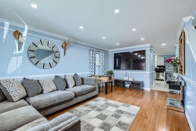 living room with crown molding and light hardwood / wood-style floors