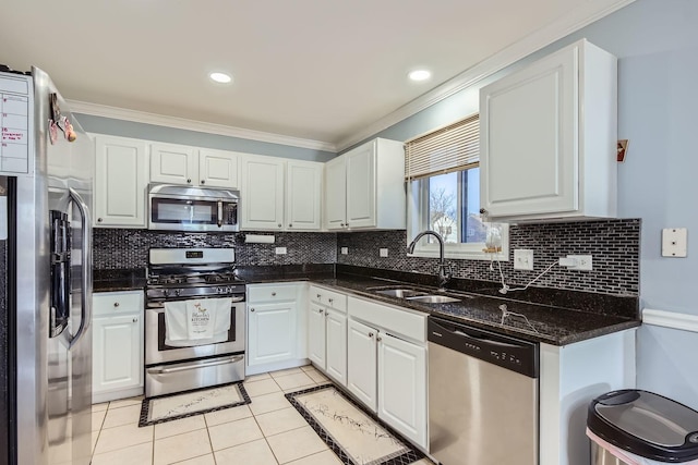 kitchen with appliances with stainless steel finishes, sink, light tile patterned floors, and white cabinets