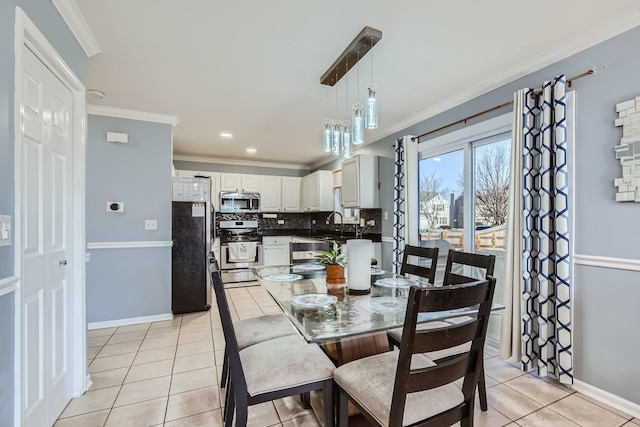 tiled dining area featuring sink and crown molding