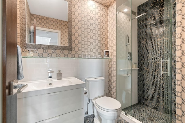 bathroom featuring walk in shower, tile walls, vanity, and toilet