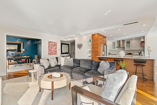 living room with sink and light hardwood / wood-style flooring