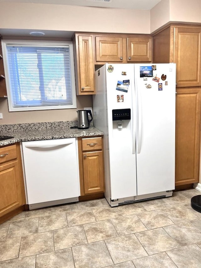 kitchen featuring white appliances and light stone countertops