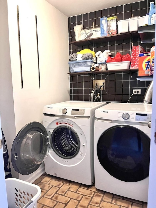 clothes washing area with washing machine and dryer