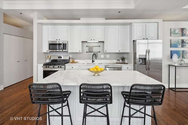 kitchen with white cabinetry, light stone countertops, appliances with stainless steel finishes, and sink