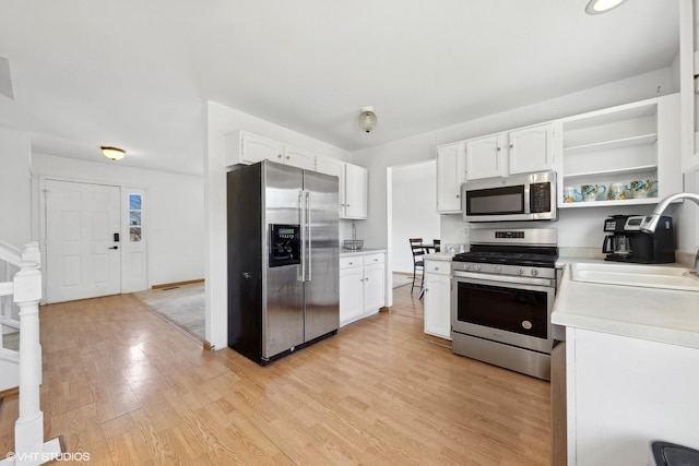 kitchen with stainless steel appliances, sink, and white cabinets