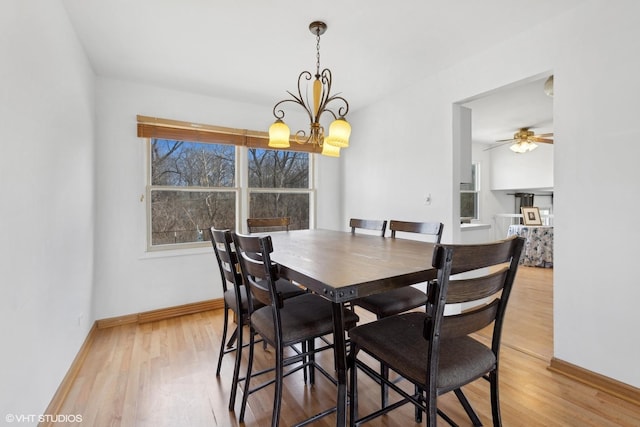 dining room featuring wood-type flooring and ceiling fan with notable chandelier