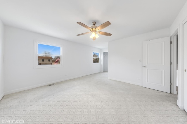 carpeted spare room with ceiling fan