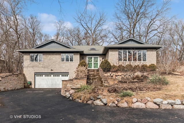 view of front of property with aphalt driveway, brick siding, and a garage