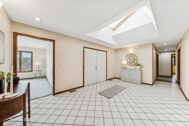 foyer entrance with light tile patterned floors, recessed lighting, a skylight, visible vents, and baseboards