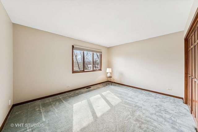 unfurnished room with carpet floors and baseboards