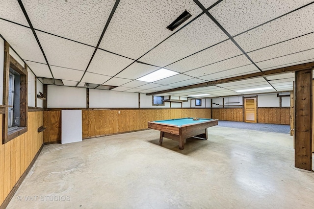 game room with concrete floors, wood walls, and a paneled ceiling