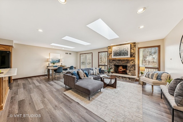 living area featuring a fireplace, recessed lighting, visible vents, wood finished floors, and baseboards