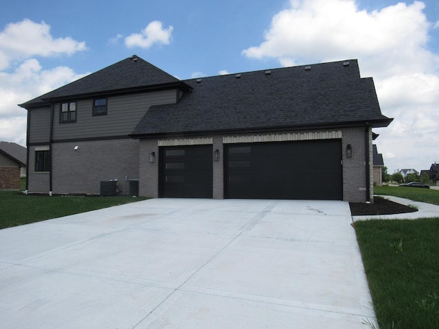 exterior space featuring central AC, a garage, and a front lawn