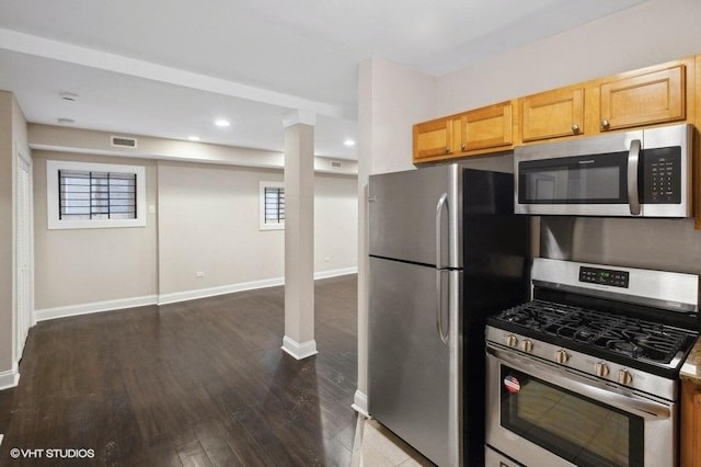 kitchen featuring appliances with stainless steel finishes, dark hardwood / wood-style floors, and light brown cabinets