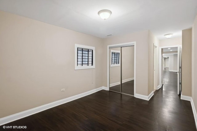 unfurnished bedroom featuring dark hardwood / wood-style floors and a closet