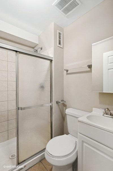 bathroom featuring vanity, tile patterned floors, toilet, and walk in shower