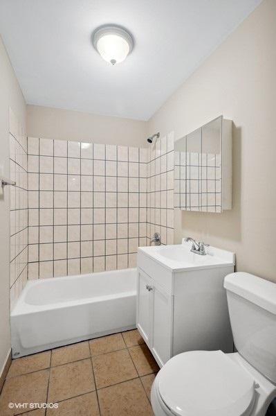 full bathroom with vanity, toilet, tiled shower / bath combo, and tile patterned flooring