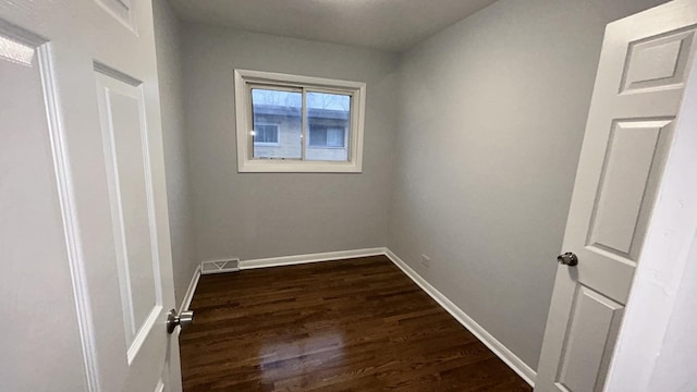 unfurnished room with dark hardwood / wood-style flooring