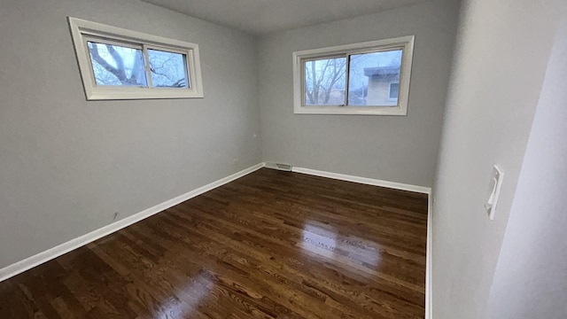 unfurnished room with dark hardwood / wood-style flooring and a wealth of natural light