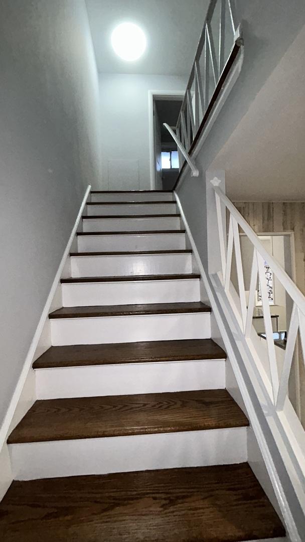 stairs featuring hardwood / wood-style floors