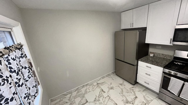 kitchen with white cabinetry, dark stone counters, and appliances with stainless steel finishes