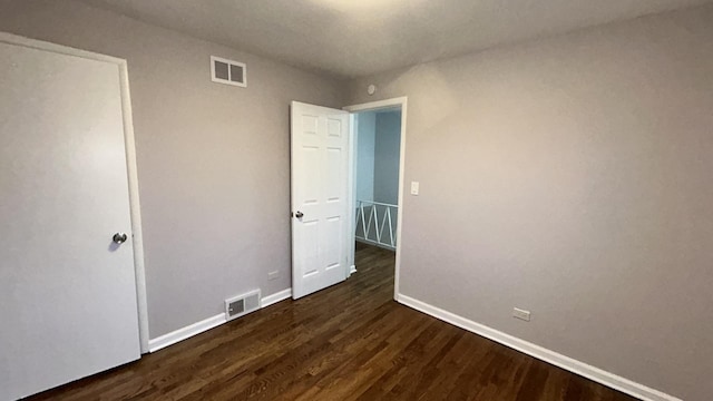 unfurnished bedroom with dark hardwood / wood-style flooring