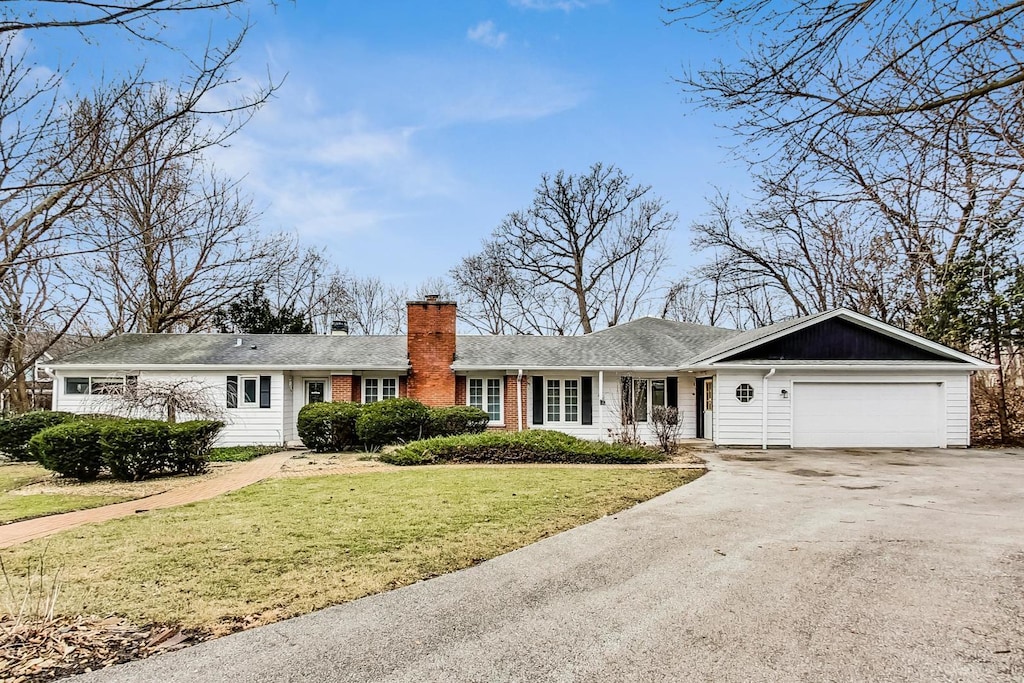 ranch-style home featuring a garage and a front yard