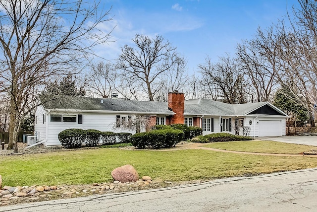 single story home with a garage and a front lawn