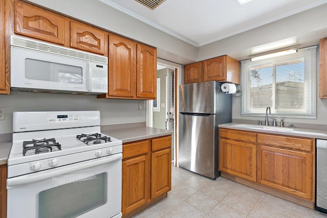 kitchen featuring ornamental molding, appliances with stainless steel finishes, sink, and light tile patterned floors