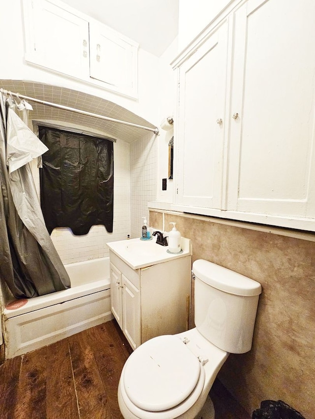 full bathroom featuring shower / tub combo with curtain, hardwood / wood-style floors, vanity, and toilet