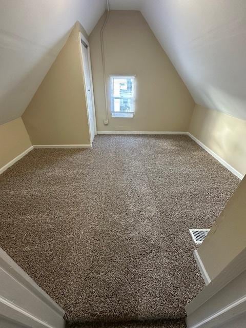 bonus room featuring vaulted ceiling and carpet