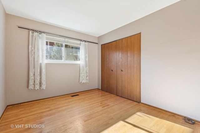 unfurnished bedroom with hardwood / wood-style floors and a closet