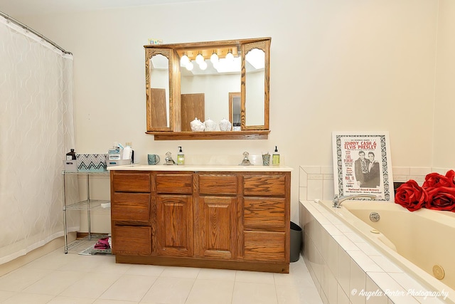 bathroom with tiled tub, vanity, and tile patterned flooring