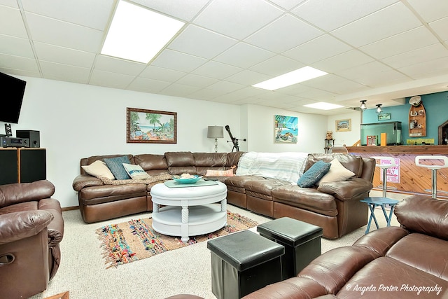 carpeted living room featuring a drop ceiling