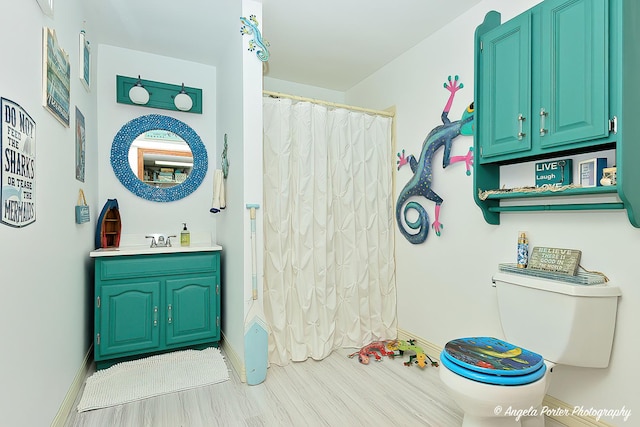 full bathroom featuring vanity, hardwood / wood-style floors, shower / bath combo, and toilet